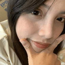 a close up of a woman 's face with a box in the background that says eps