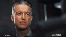 a close up of a man 's face with the nbc logo on the bottom