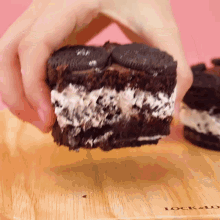 a person is holding a piece of oreo cake