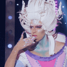 a woman wearing a white wig with candles in it