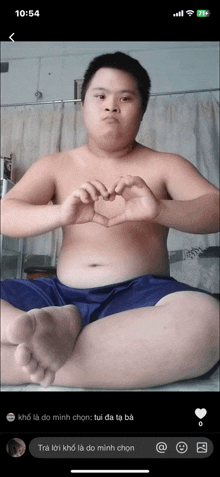 a shirtless man is making a heart with his hands