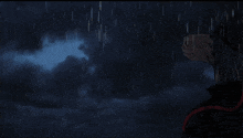 a person is standing in the rain looking up at the sky