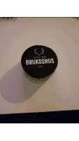 a hand is holding a black container that says bruk on it