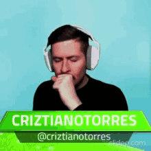 a man wearing headphones is pointing at a green sign that says ' cristianotorres '