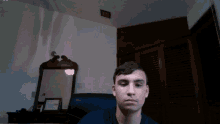 a young man sitting in front of a mirror in a room