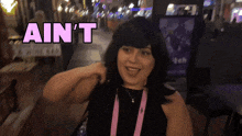 a woman says ain 't while standing in front of a sign