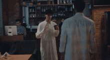 a man in a white shirt is standing next to another man