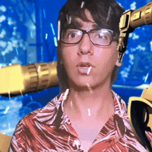 a man wearing glasses is standing in front of a robotic arm with the letter o on it