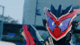 a close up of a mask with purple eyes and a red heart on it