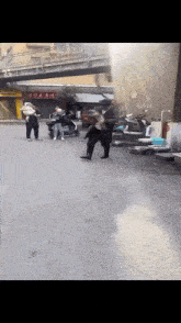 a group of people standing on a street in front of a sign that says ' chinese '