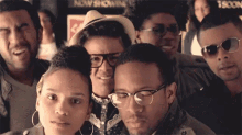 a group of people are posing for a picture with a sign that says now showing