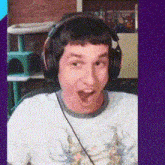 a man wearing headphones and a white shirt looks surprised