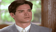 a man in a suit and tie is looking to the side