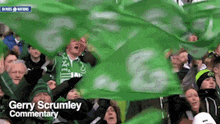 a crowd of people holding green flags with the words gerry scrumley commentary written on the bottom