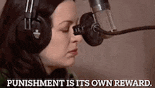 a woman wearing headphones is talking into a microphone and the words punishment is its own reward are visible .