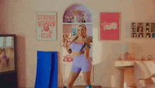 a woman is holding a jump rope and a yoga mat in a living room .