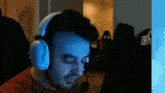 a man wearing headphones and a microphone is sitting in front of a computer monitor .