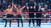 a group of men standing in a wrestling ring with a sign that says ' wwe '