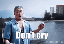 a man in a blue shirt says " don 't cry " in front of a river