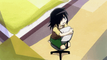 a girl is sitting on a chair hugging a pillow and a tv screen behind her says tokyo
