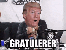 a man sitting in front of a microphone with donald trump 's head on his face and the words gratulerer below him