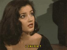 a woman in a black dress is making a funny face .
