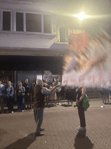 a group of people are gathered outside of a building that says ' imperial ' on it
