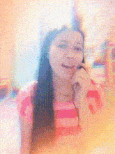 a woman in a pink and white striped shirt is smiling