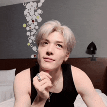a man wearing a black tank top and a ring on his finger