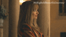 a woman standing next to a pillar with #abigbold beautiful journey written above her