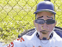 a man wearing sunglasses and a baseball cap is sitting in a chair