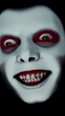 a close up of a scary face with red eyes and teeth
