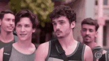 a group of young men are standing next to each other in a line .