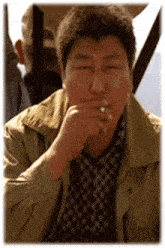 a man smoking a cigarette with his hand on his mouth