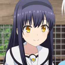 a girl with long blue hair and yellow eyes smiles for the camera
