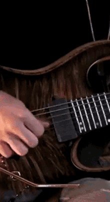 a close up of a person playing a guitar with a pink background