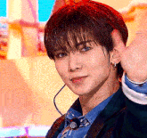 a young man wearing a suit and tie with a microphone around his neck