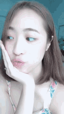 a woman with a ring on her finger rests her hand on her face