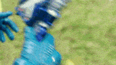 a person wearing blue gloves holds a blue object in their hand