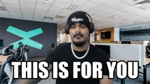 a man wearing headphones and a hat says this is for you