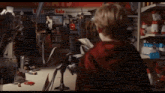 a boy in a red hoodie stands in front of a store with a sign that says bargains on it