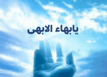 a hand is reaching up towards a blue sky with arabic writing