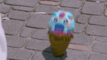 an ice cream cone with a face painted on it is on the ground