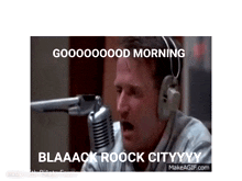 a man wearing headphones is sitting in front of a microphone and saying good morning .