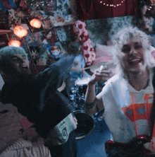 a man holding a lighter and a woman holding a guitar in a bedroom