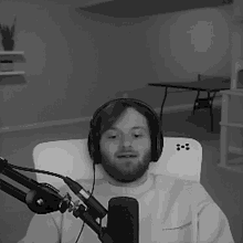 a man wearing headphones is sitting in front of a microphone in a black and white photo