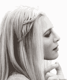 a woman with long blonde hair has a braid in her hair ..