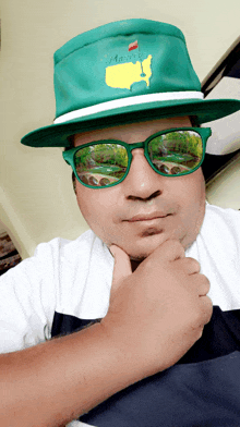a man wearing a green hat and green sunglasses with the word masters on it