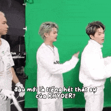 a group of young men are standing next to each other on a green screen .