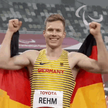 a man with the name rehm on his shirt is holding a flag